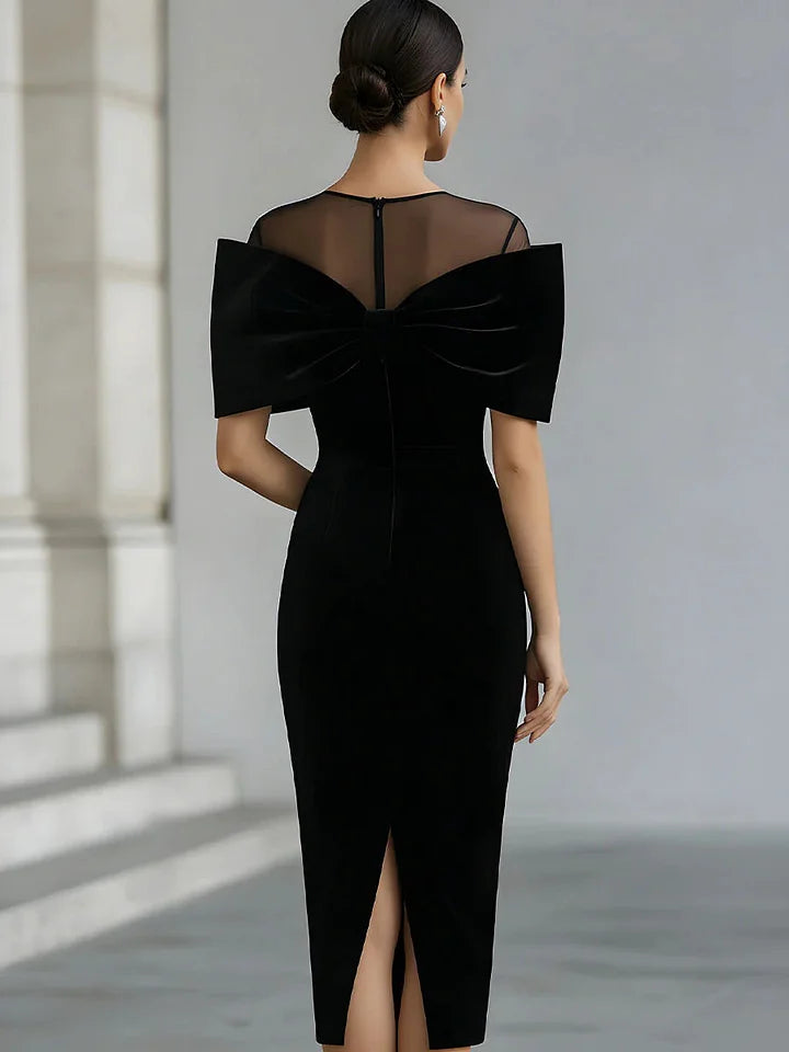 Vestido midi dramático em veludo preto com laço.