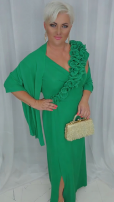 O vestido apresenta um decote em V adornado com folhos em estampado floral