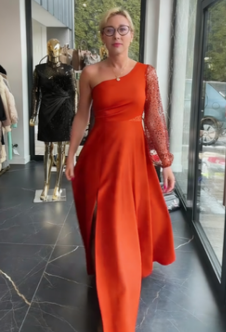 Vestido de um ombro só com mangas de lantejoulas e detalhes em tule.