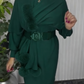 Um vestido de mangas compridas com decote redondo e um xaile decorado com elementos de pelúcia.