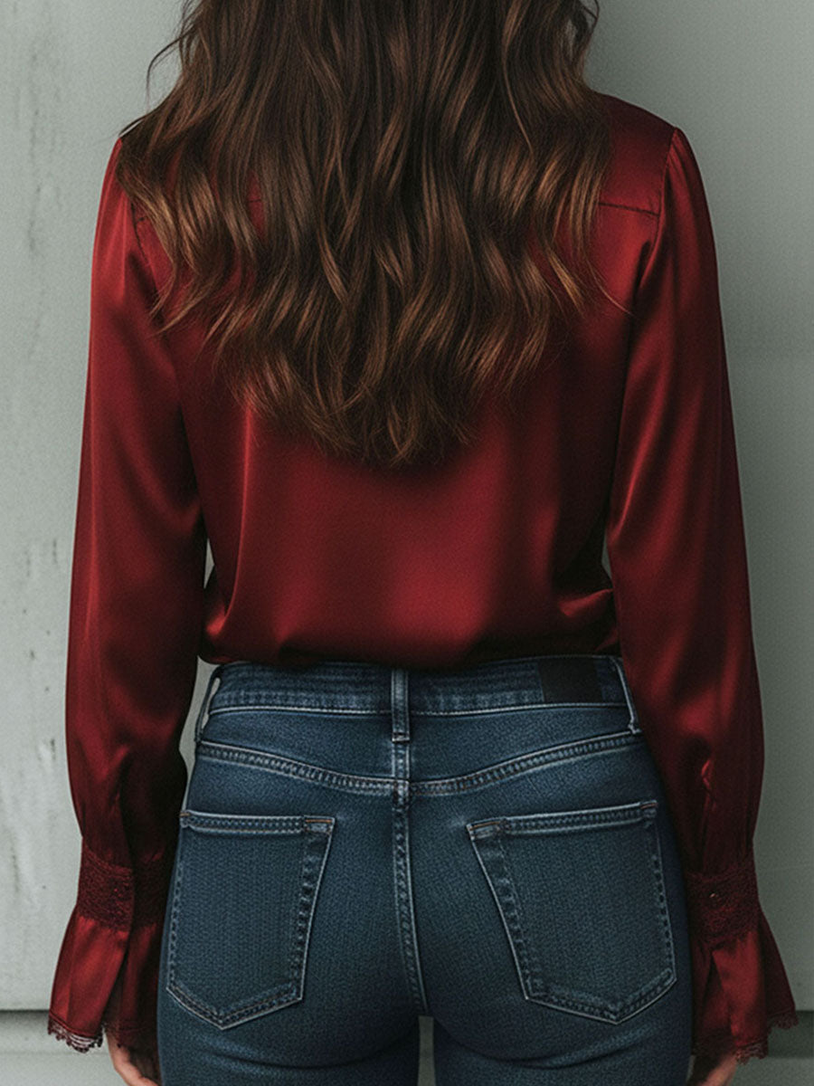Uma elegante blusa de cetim cor de vinho com mangas largas e detalhes em renda