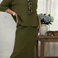Elegante conjunto de duas peças composto por camisola de gola alta e saia de malha.