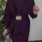 Um vestido de mangas compridas com decote redondo e um xaile decorado com elementos de pelúcia.