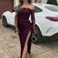 Um vestido sexy e elegante de mangas compridas com ombros à mostra, detalhes em renda e uma racha
