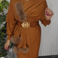 Um vestido de mangas compridas com decote redondo e um xaile decorado com elementos de pelúcia.