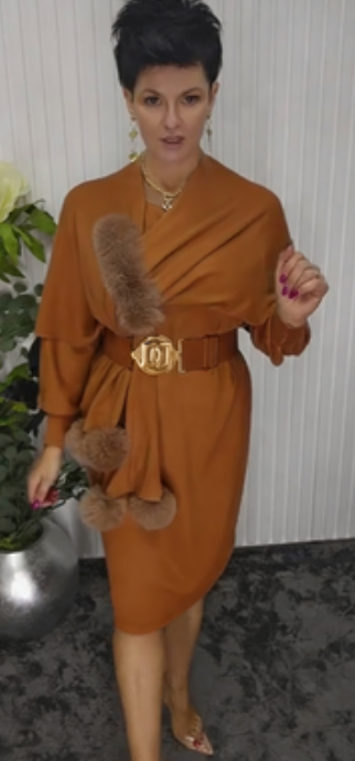 Um vestido de mangas compridas com decote redondo e um xaile decorado com elementos de pelúcia.