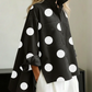 Blusa elegante e artística com estampado de bolinhas e gola alta.