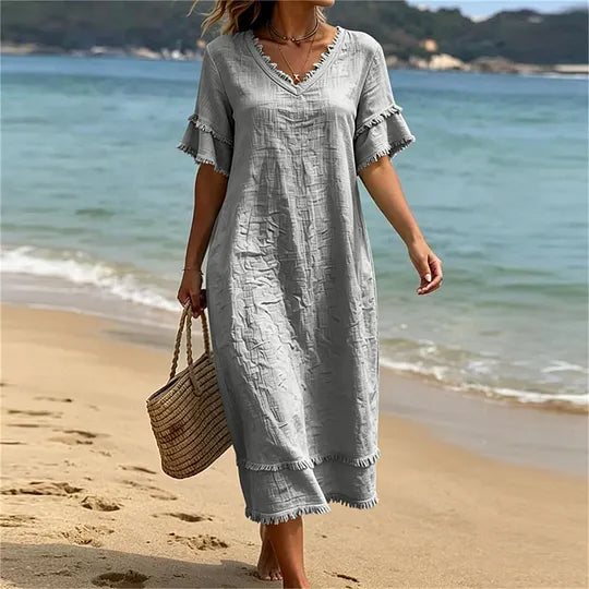 Vestido de mulher em algodão com decote em V, corte largo e borlas.