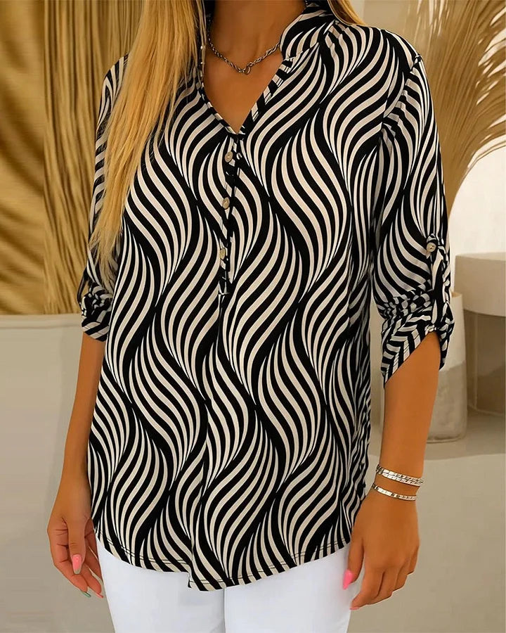 Blusa de menina com estampado geométrico e decote em V, fechada com botões.