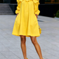 Elegante minivestido de cor única, corte em A e decote ombro a ombro.