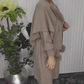 Um vestido de mangas compridas com decote redondo e um xaile decorado com elementos de pelúcia.
