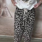 Boné de beisebol estampado, blusa de lantejoulas + calças de alfaiataria largas com padrão leopardo