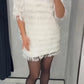 Conjunto casual de menina composto por blusa de gola redonda com franjas e saia de cor lisa