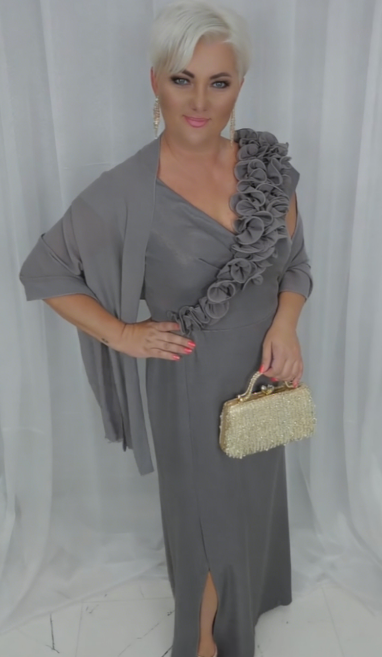 O vestido apresenta um decote em V adornado com folhos em estampado floral