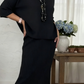 Elegante conjunto de duas peças composto por camisola de gola alta e saia de malha.