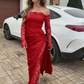 Um vestido sexy e elegante de mangas compridas com ombros à mostra, detalhes em renda e uma racha