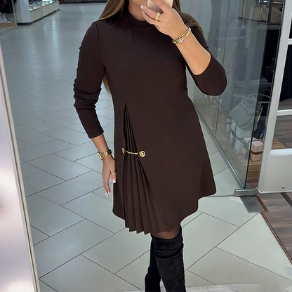 Um elegante vestido de mangas compridas com detalhes plissados.