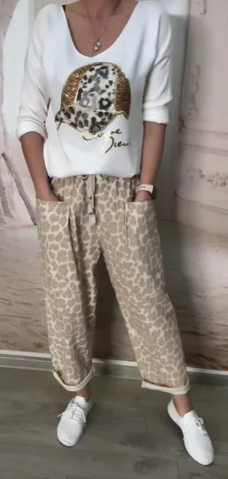 Boné de beisebol estampado, blusa de lantejoulas + calças de alfaiataria largas com padrão leopardo