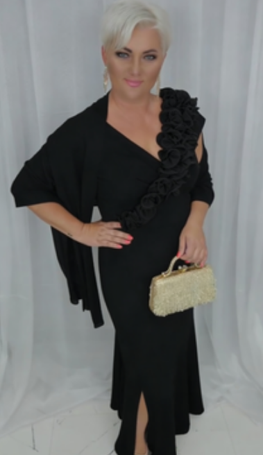 O vestido apresenta um decote em V adornado com folhos em estampado floral