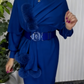 Um vestido de mangas compridas com decote redondo e um xaile decorado com elementos de pelúcia.
