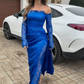 Um vestido sexy e elegante de mangas compridas com ombros à mostra, detalhes em renda e uma racha