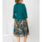 Um vestido elegante com gola vazada e cinto em forma de folha.